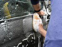 a man washing a car with a sponge